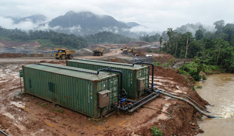 Papua Water Treatment Supplier: Heavy-duty containerized WTP unit at a misty open-pit mine in the remote interior of Timika.